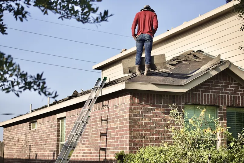 Professional roofer working on a residential roof in Saint Georges